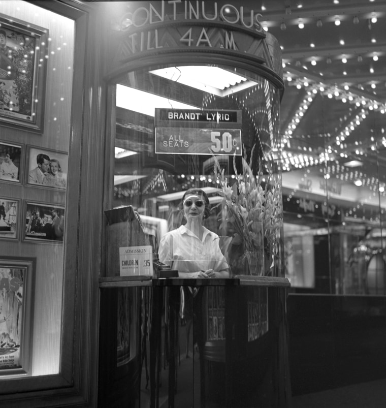 A woman peers out from a ticket booth of a movie theater in New York's Times Square in 1954. One thing that hasn't endured since Frank Larson took these photos: the price of a ticket.